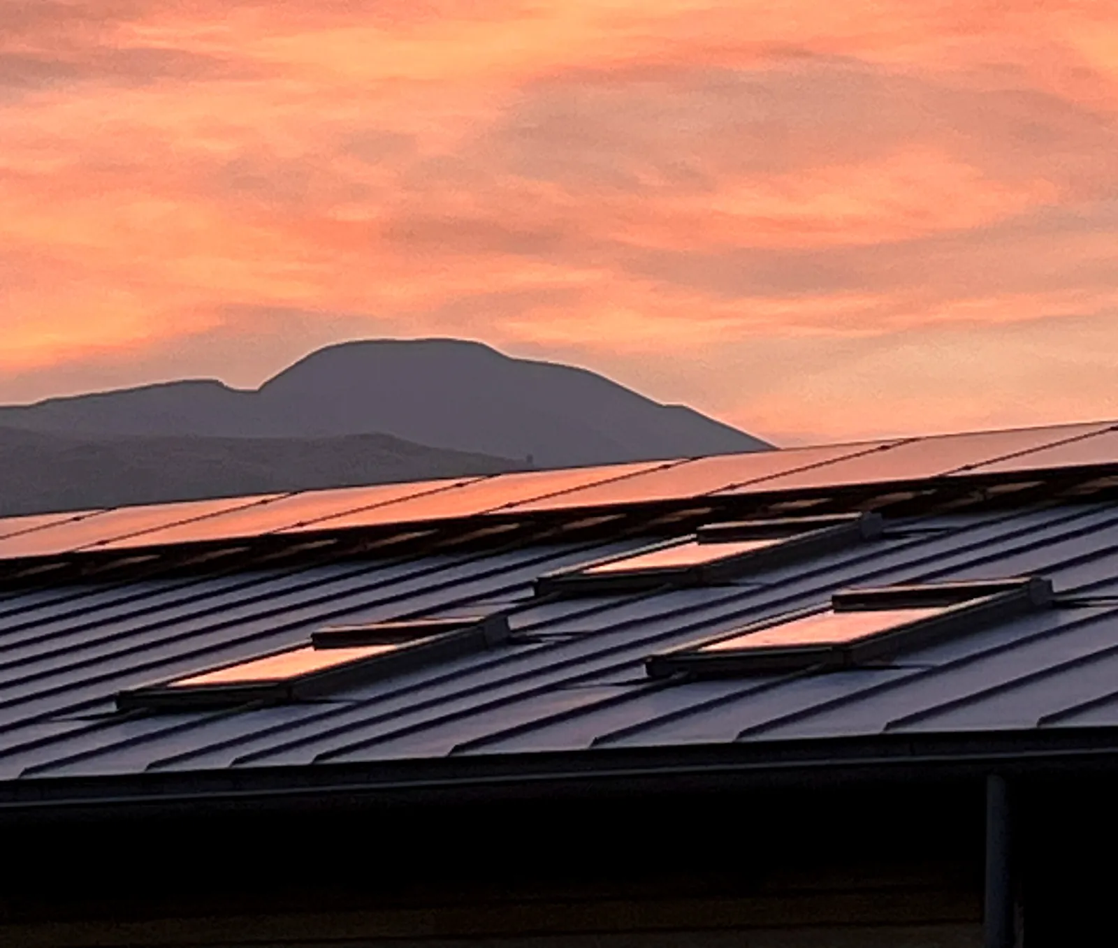 Golden-hour sky above solar panels installed near Loch Venachar, Callander